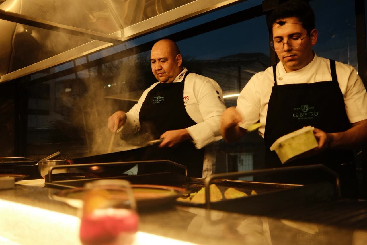 Dos chefs cocinando con vapor saliendo del wok